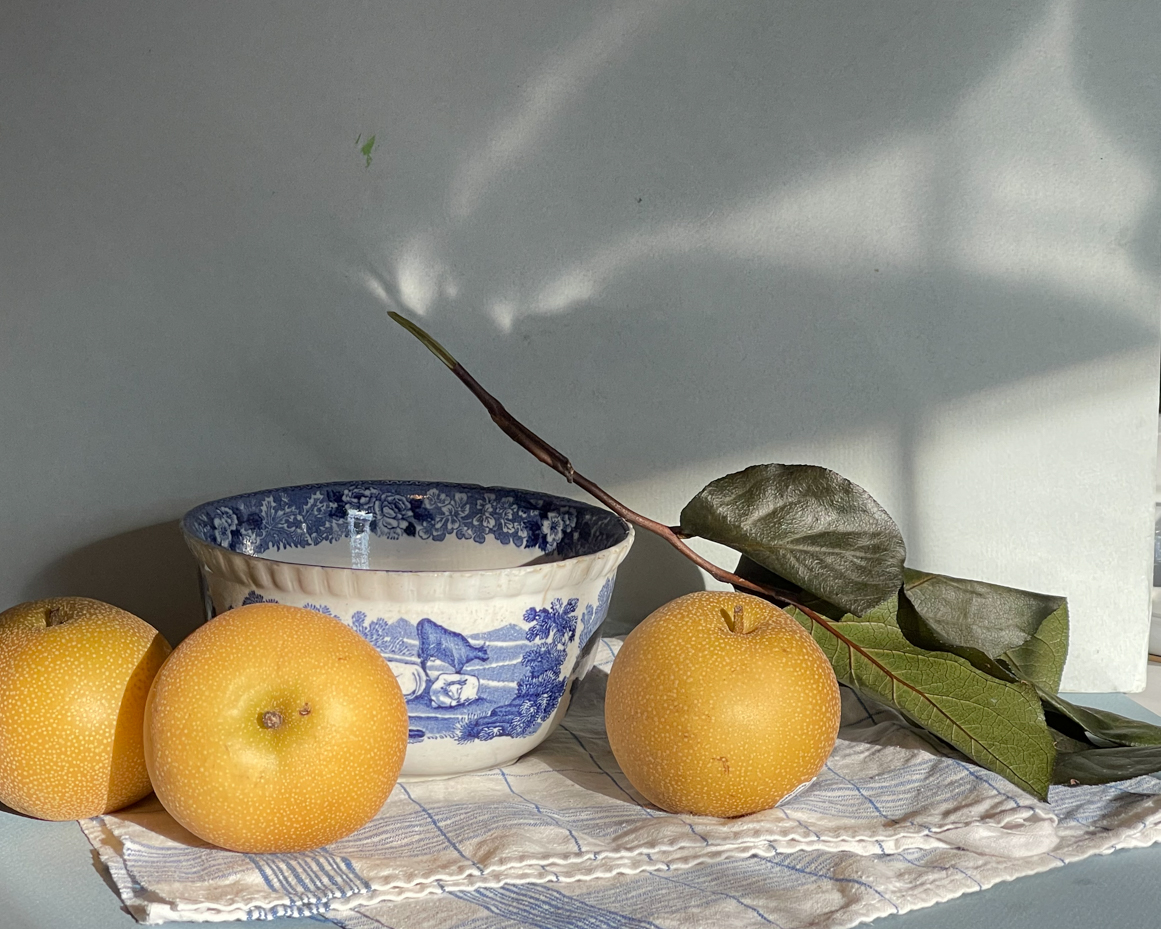 asian-pear-with-leaves-next-to-bowl