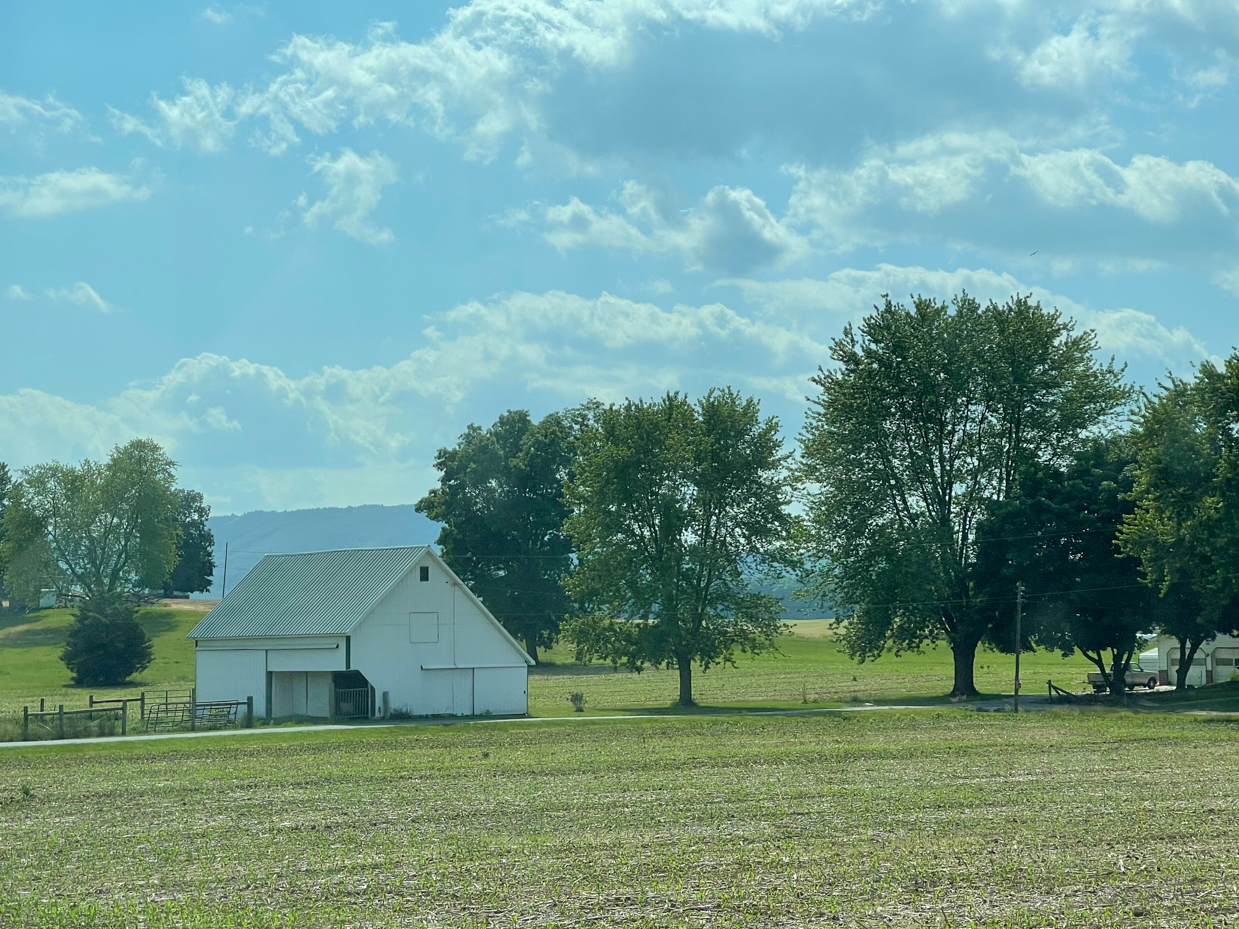 barn-with-trees-and-clouds-with-farm-fields