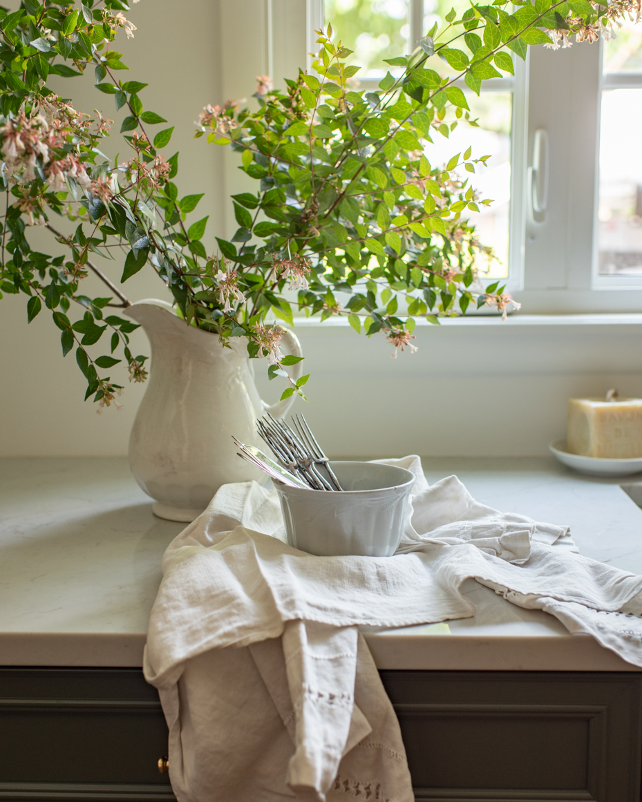 fork-and-knife-in-bowl-with-greenery-in-vase