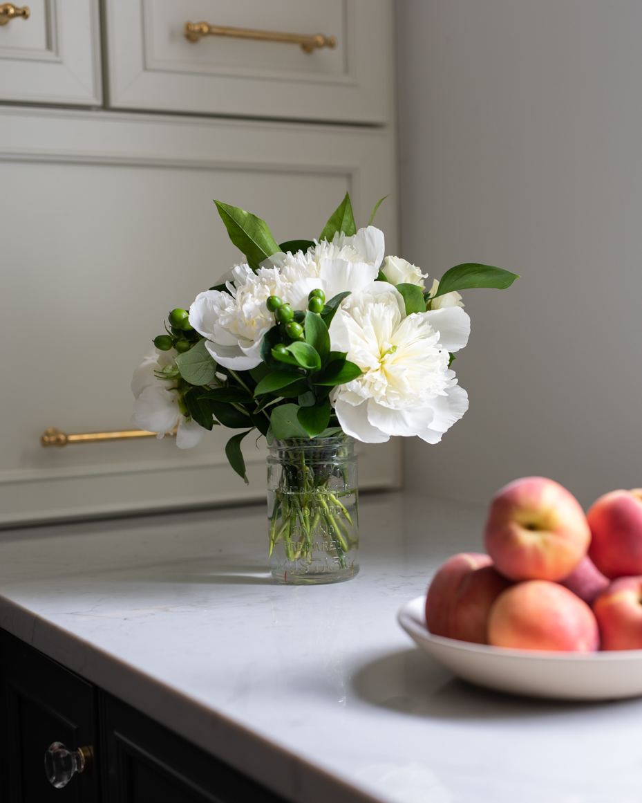 white-flowers-in-clear-vase-with-peaches