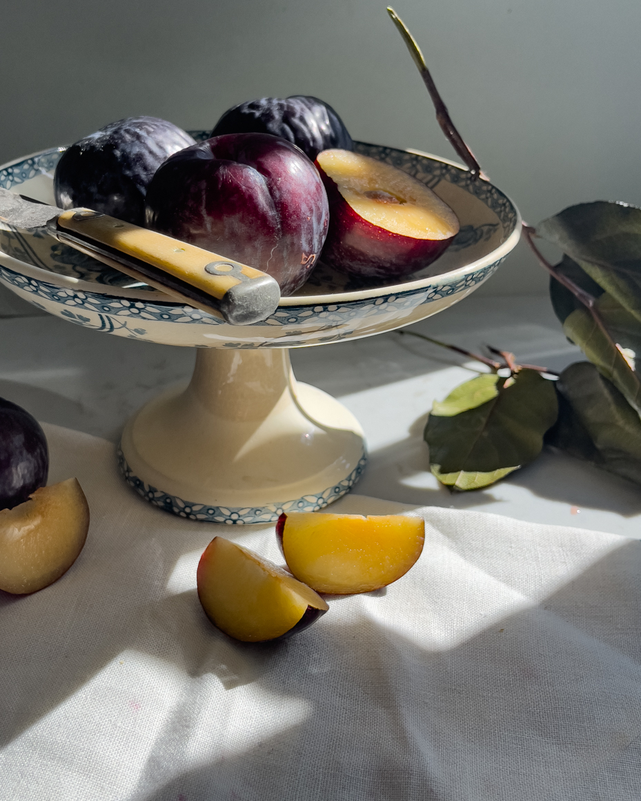 plums-and-plum-slices-on-pedestal