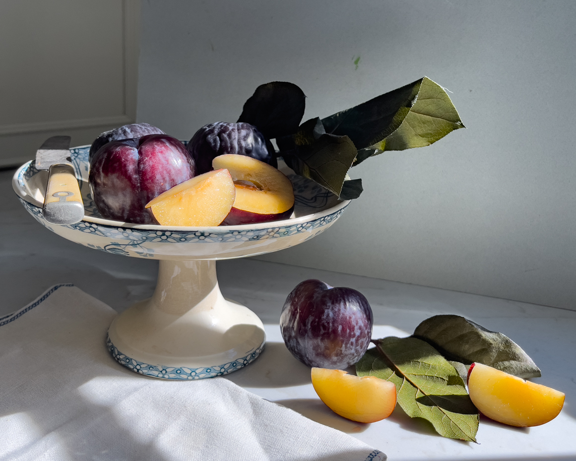 plums-and-plum-slices-on-pedestal