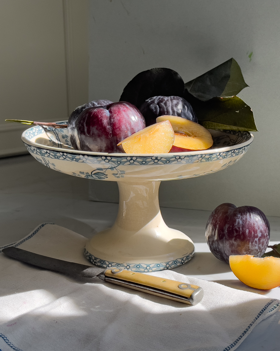 plums-and-plum-slices-on-pedestal