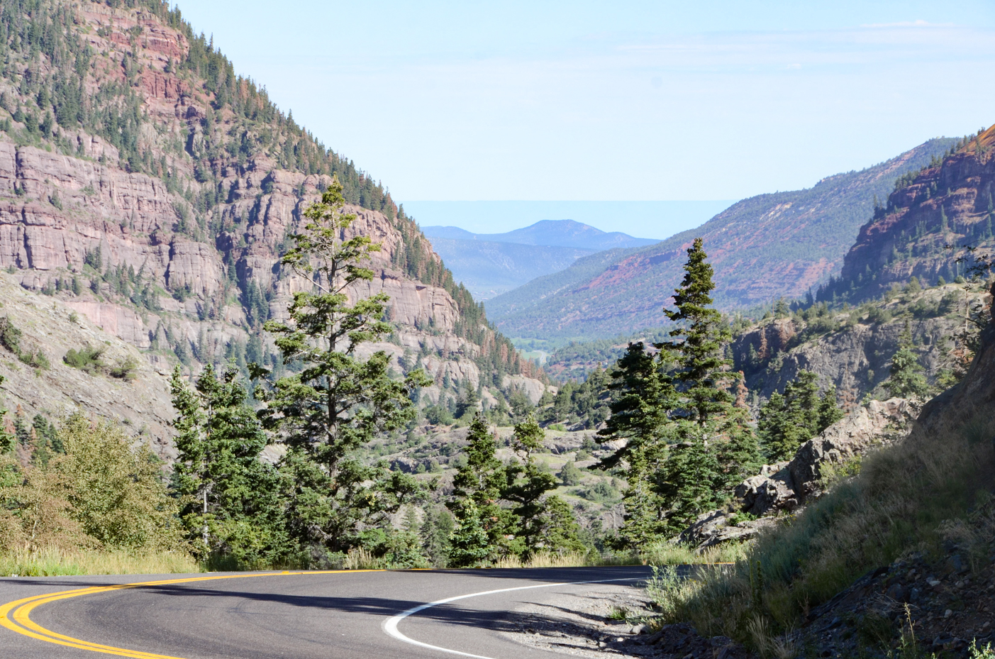 scenic-rocky-mountain-road-trip-winding-highway-through-forested-canyon-landscape