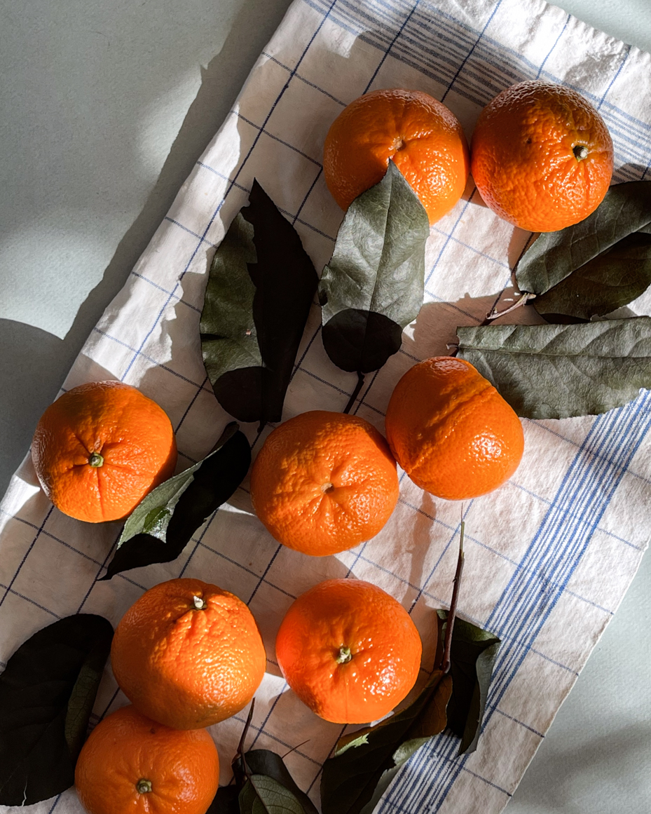 tangerines-with-leave-on-dish-cloth