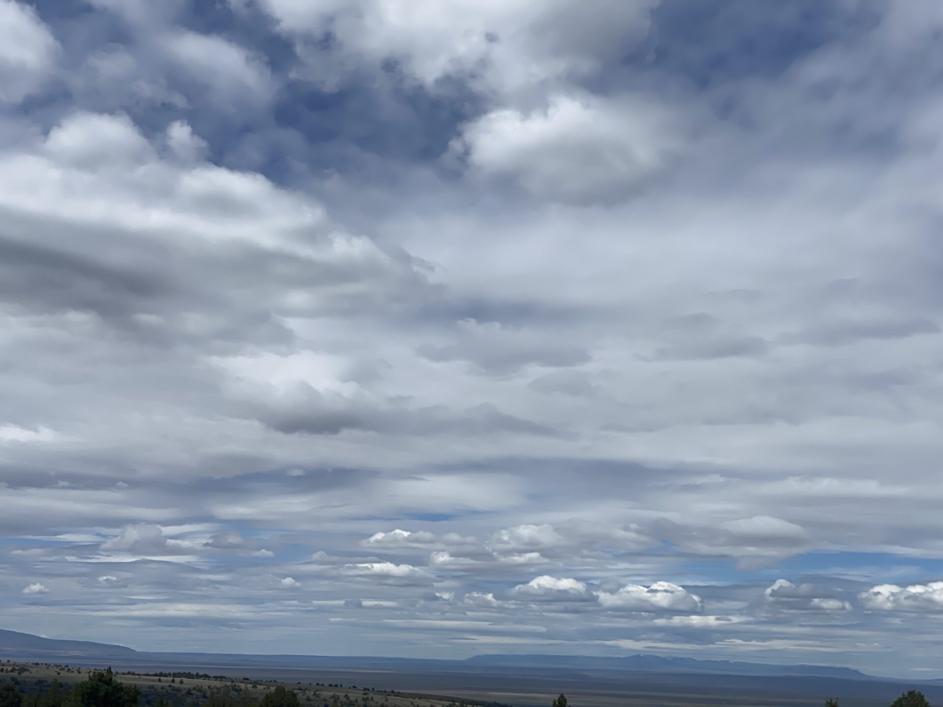 cloudy-sky-over-open-landscape-with-distant-mountains