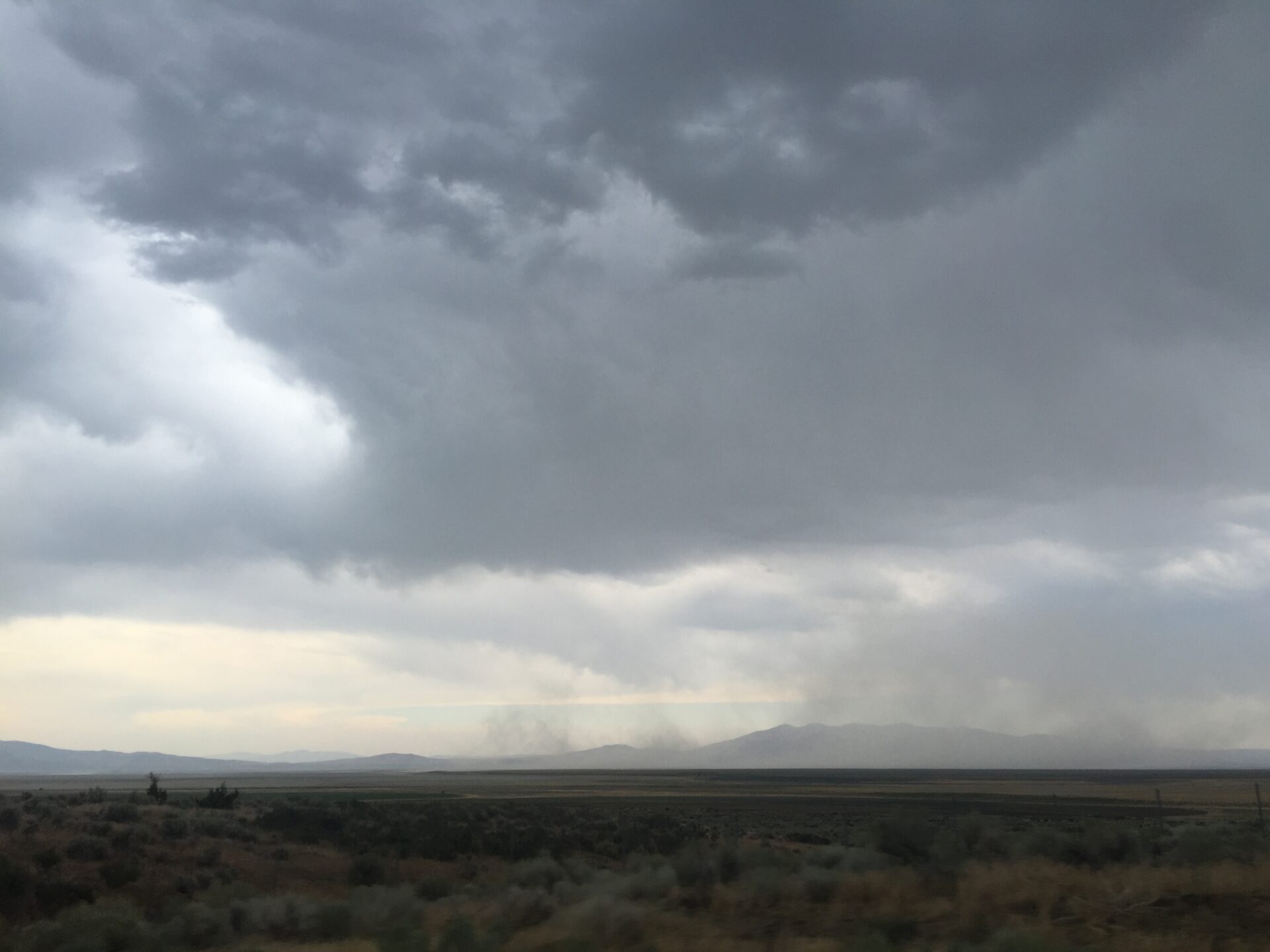 vast-remote-desert-plain-with-ominous-stormy-clouds-and-distant-mountains