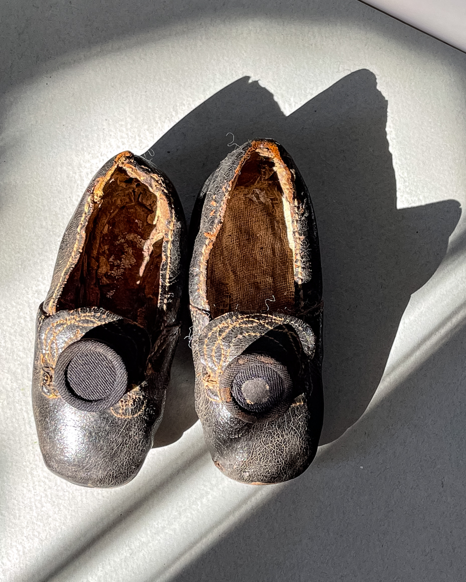 antique-worn-leather-baby-shoes-with-button-details-in-sunlight-royalty-free-reference-photo