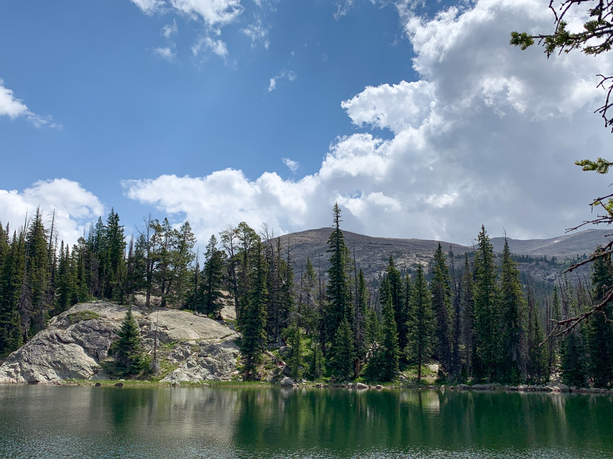 crystal-clear-alpine-lake-reflecting-evergreen-forest-and-mountain-peaks-pristine-nature-photography