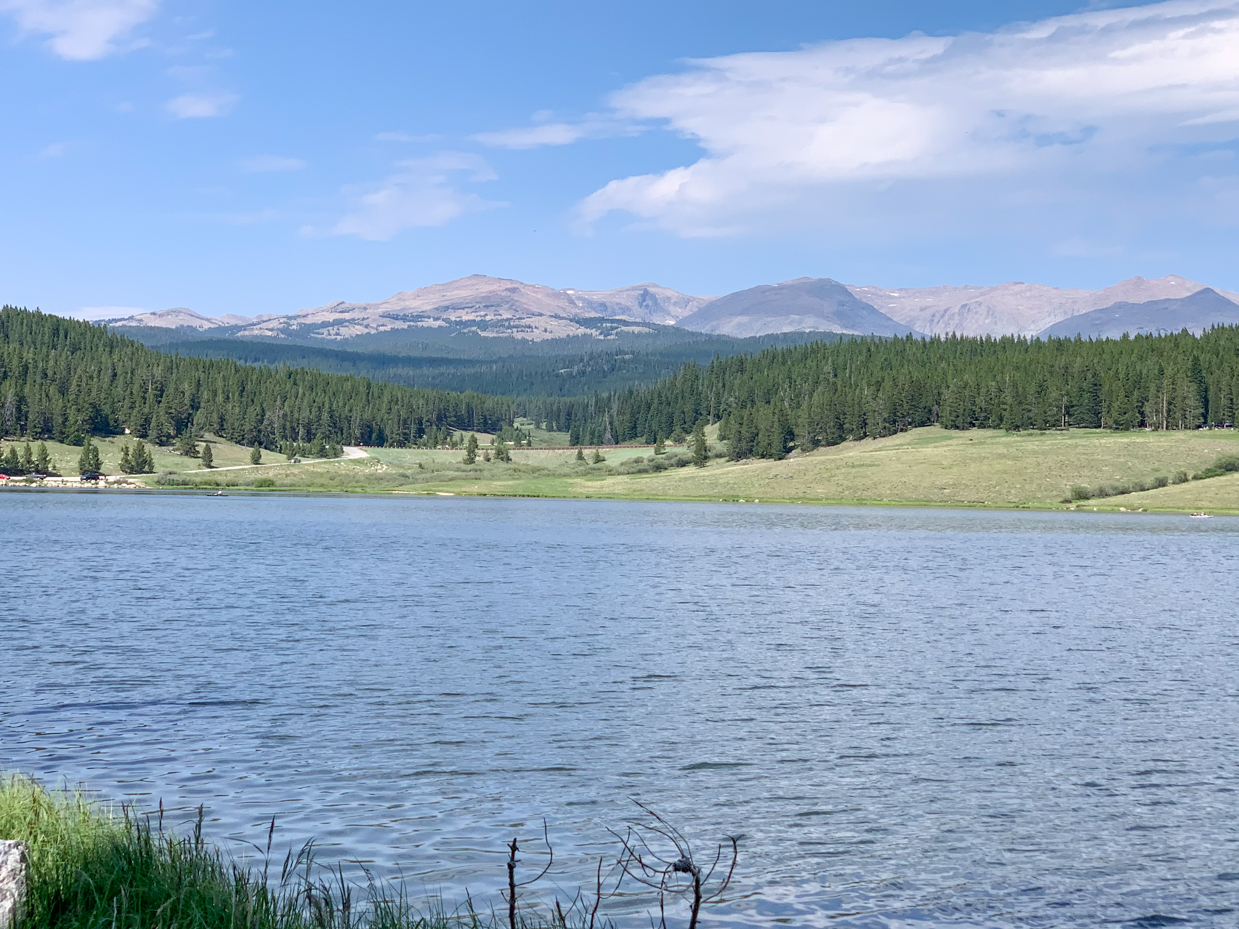 crystal-clear-lake-nestled-in-mountain-valley-with-verdant-shoreline-peaceful-wilderness-view