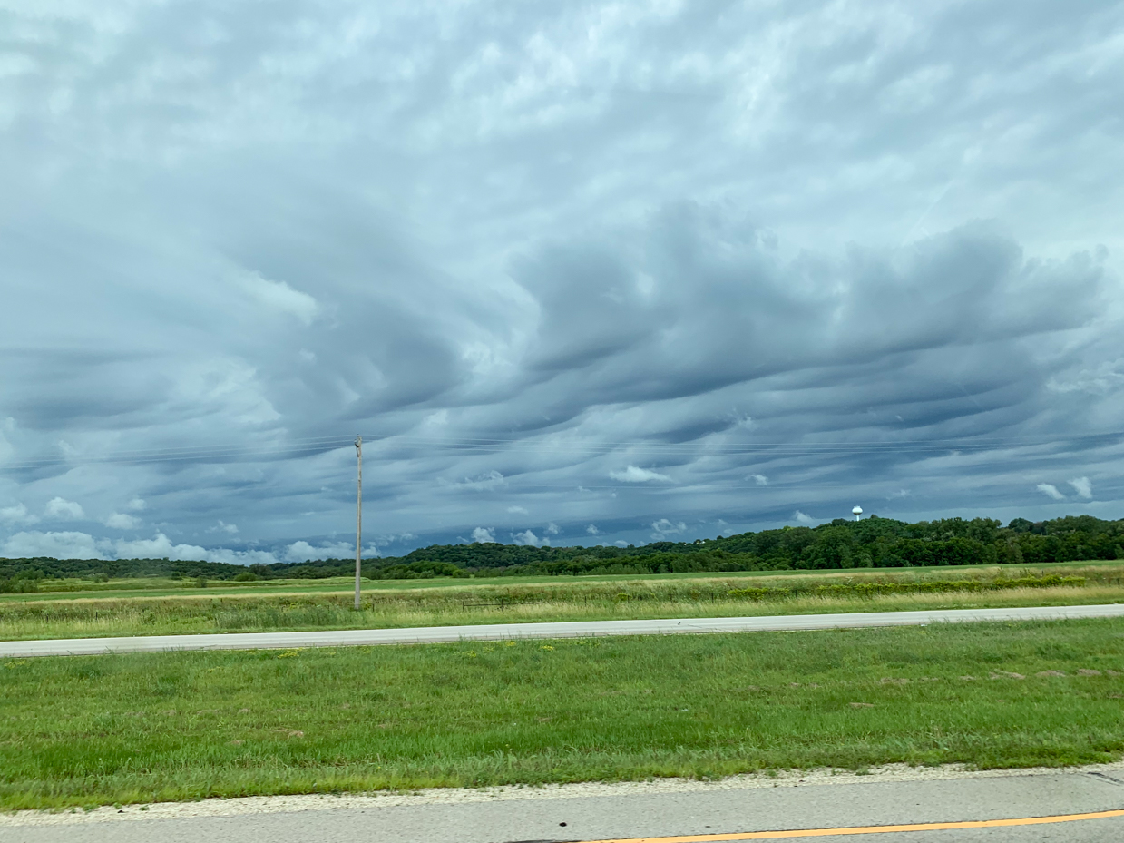 dramatic-storm-clouds-rolling-over-green-fields-and-distant-forest-royalty-free-nature-landscape-reference-photo-for-stormy-skies-weather-phenomena-and-scenic-countryside