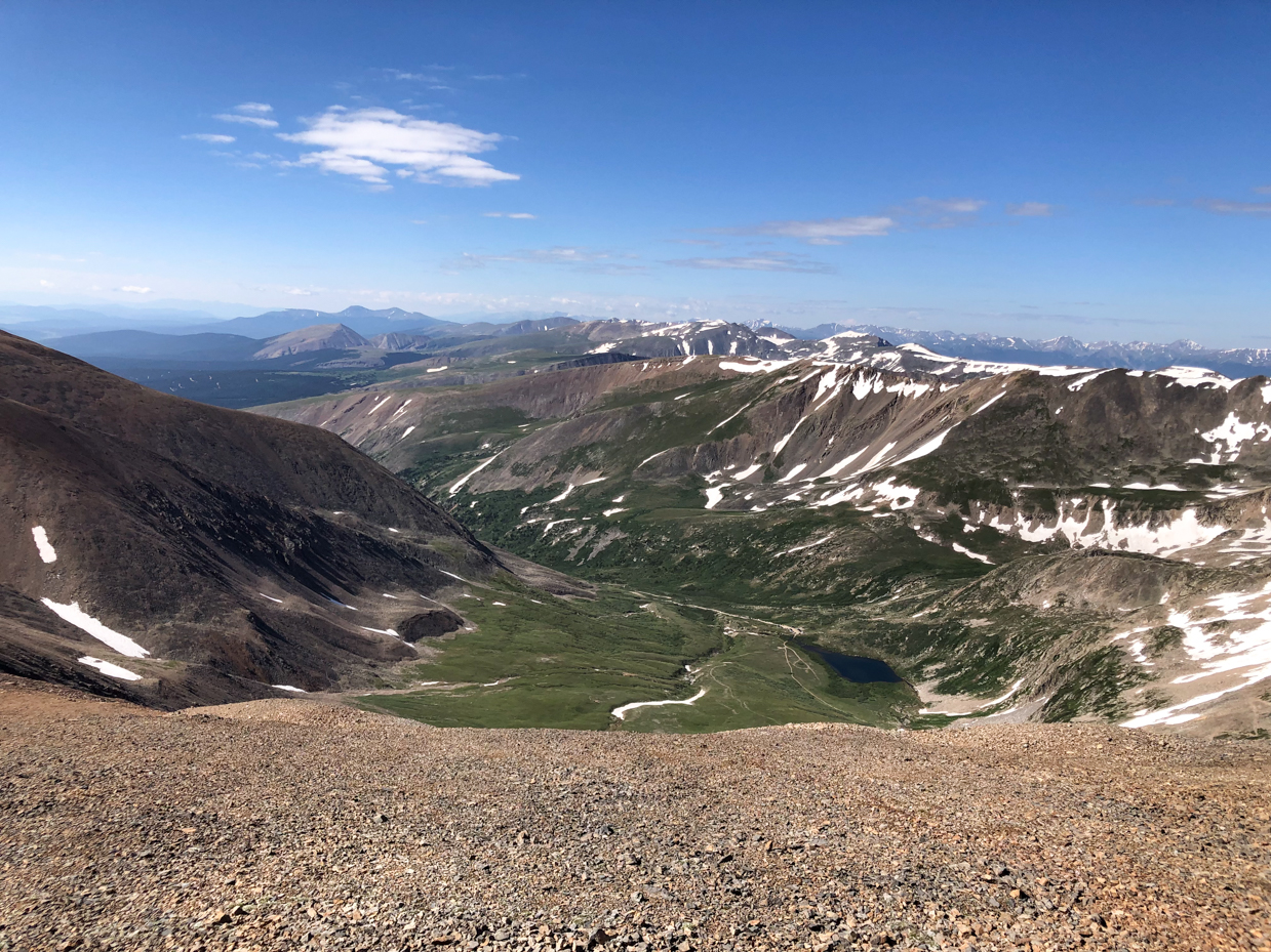 expansive-alpine-valley-with-snow-dusted-peaks-and-clear-blue-horizon