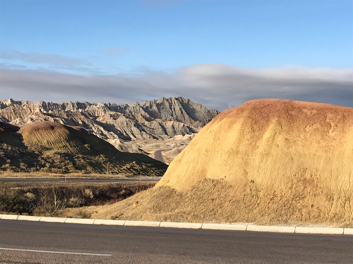 golden-hills-and-jagged-badlands-formations-under-clear-sky-royalty-free-landscape-reference-photo-for-desert-geology-eroded-terrain-and-scenic-wilderness