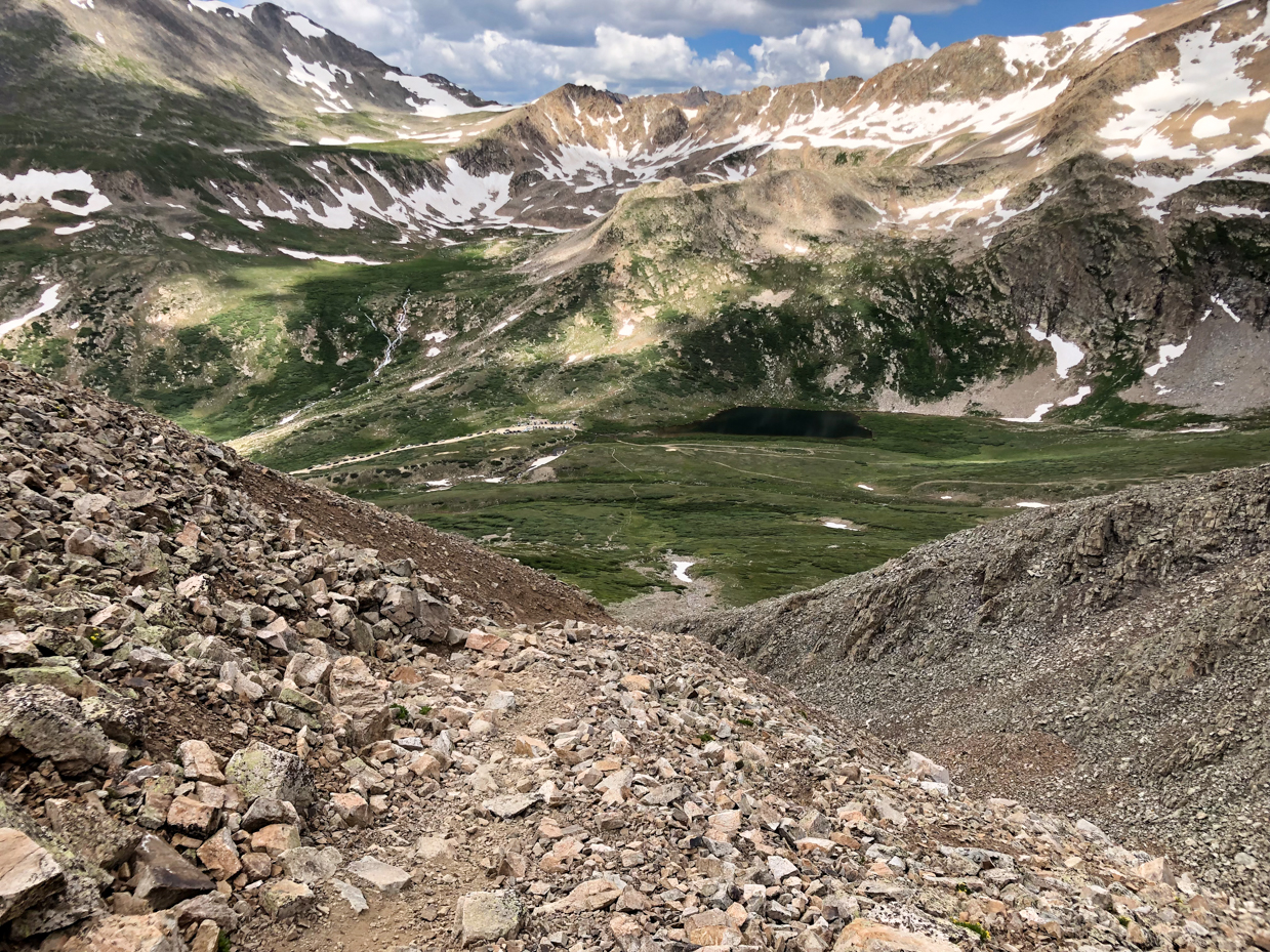 rocky-mountain-slope-with-lush-green-valley-and-snow-capped-peaks