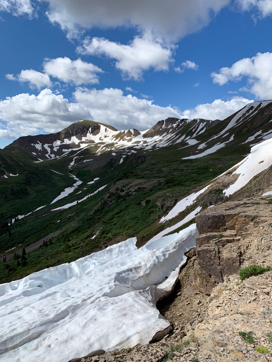 snow-covered-mountain-ridge-with-rocky-cliffside-high-altitude-alpine-landscape-for-nature-enthusiasts-and-scenic-adventure-photography