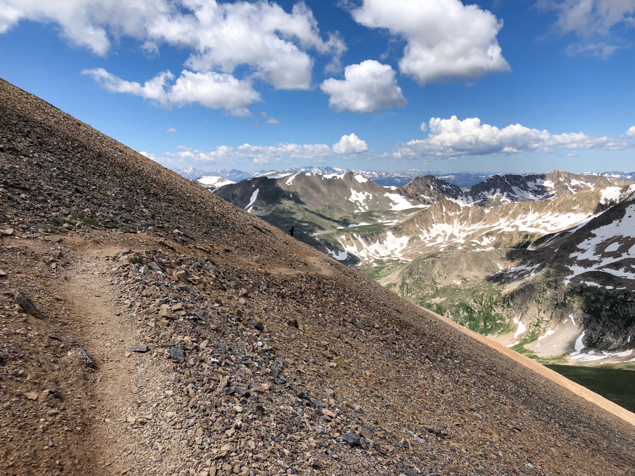 steep-mountain-trail-with-panoramic-views-of-snow-capped-peaks-and-rocky-slopes