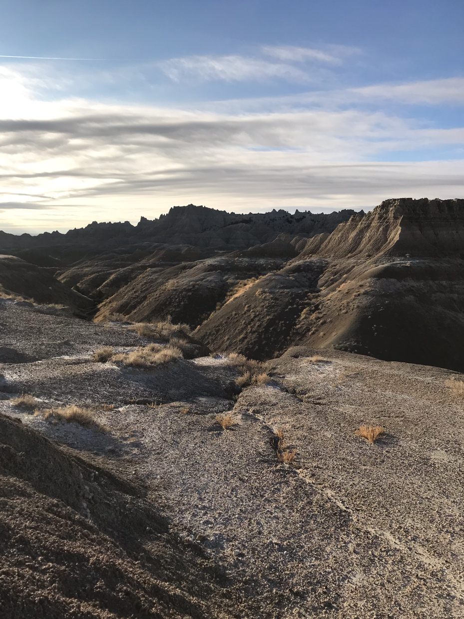 sunlit-badlands-ridge-with-eroded-rock-formations-and-dramatic-sky-royalty-free-nature-landscape-reference-photo-for-rugged-terrain-geology-and-desert-wilderness-photography