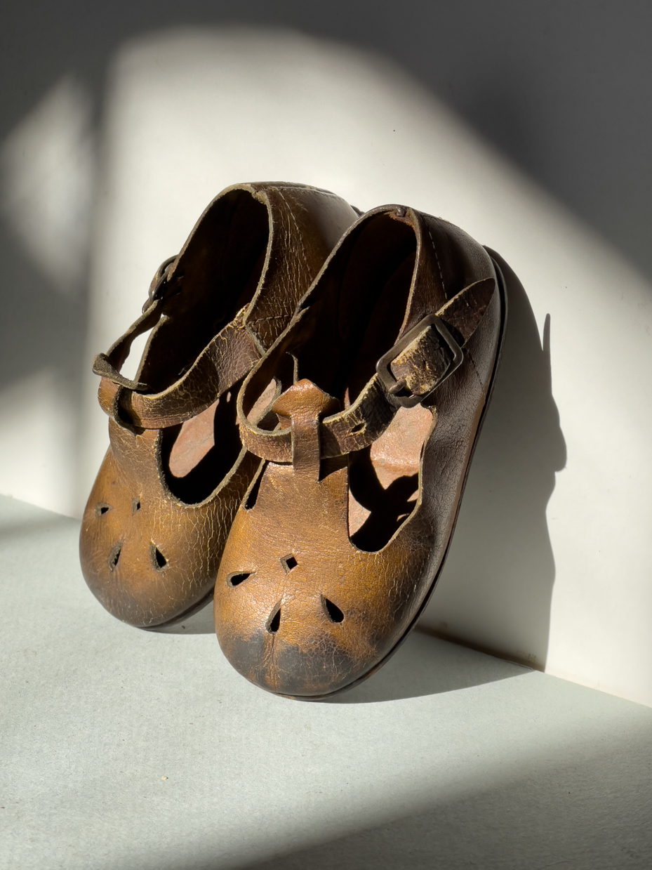 vintage-brown-leather-toddler-shoes-with-buckle-straps-and-cutout-design-in-sunlight-royalty-free-reference-photo