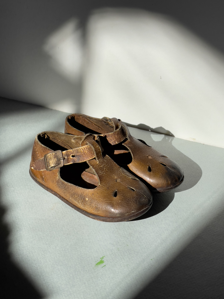 vintage-brown-leather-toddler-shoes-with-buckle-straps-and-worn-soles-in-sunlight-royalty-free-reference-photo