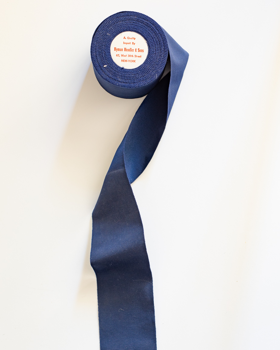 vintage-navy-blue-ribbon-roll-from-hyman-hendler-and-sons-new-york-royalty-free-reference-photo