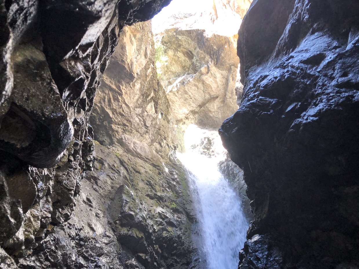 waterfall-inside-rocky-cave-dramatic-nature-photography-with-sunlit-gorge