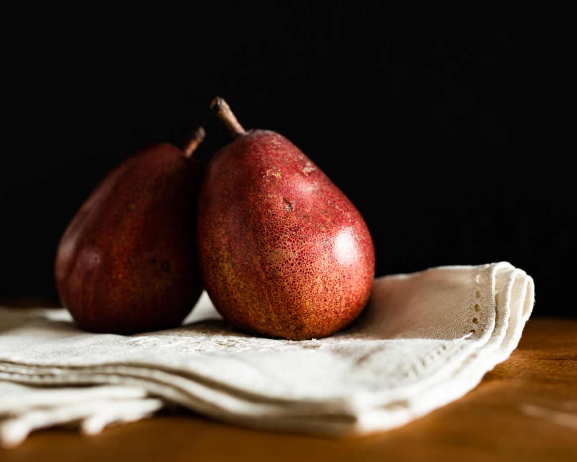 closeup-red-pears-on-white-napkin-dark-background-artist-reference