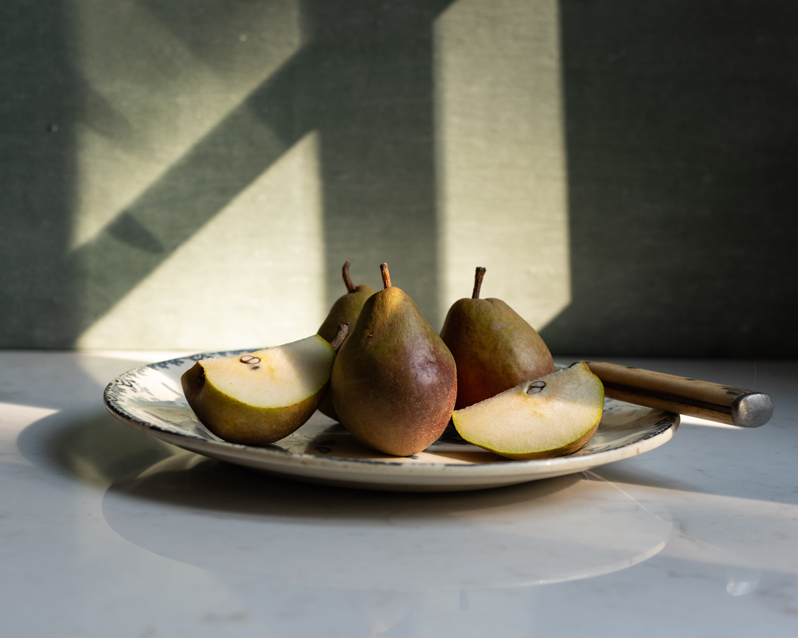 ripe-pears-on-ceramic-plate-with-rustic-background-natural-light-still-life