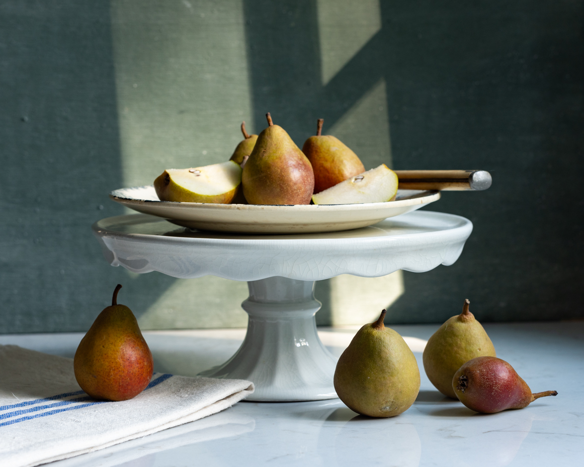 ripe-pears-on-elegant-cake-stand-with-rustic-decor-natural-light-still-life