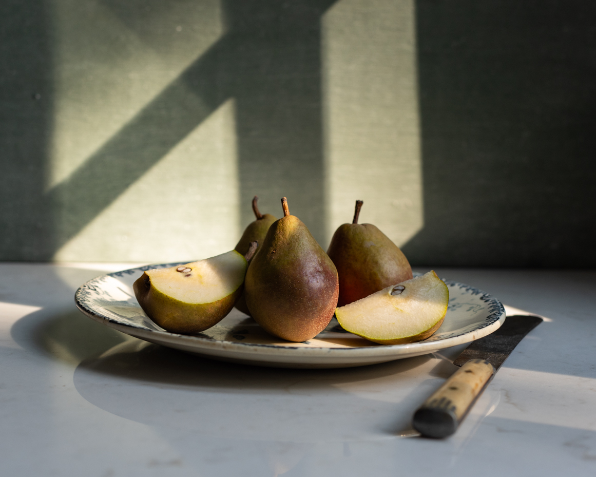 sliced-pears-on-plate-with-knife-rustic-still-life-in-natural-light