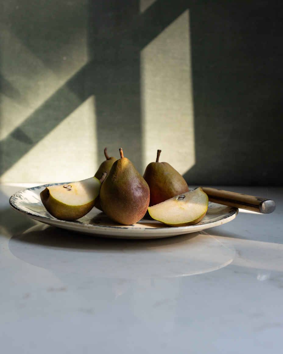 sliced-pears-on-vintage-plate-in-natural-light-rustic-still-life