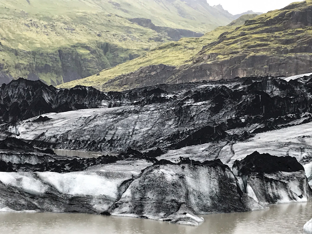 striking-black-and-white-glacier-amidst-rugged-green-cliffs-stunning-icelandic-landscape