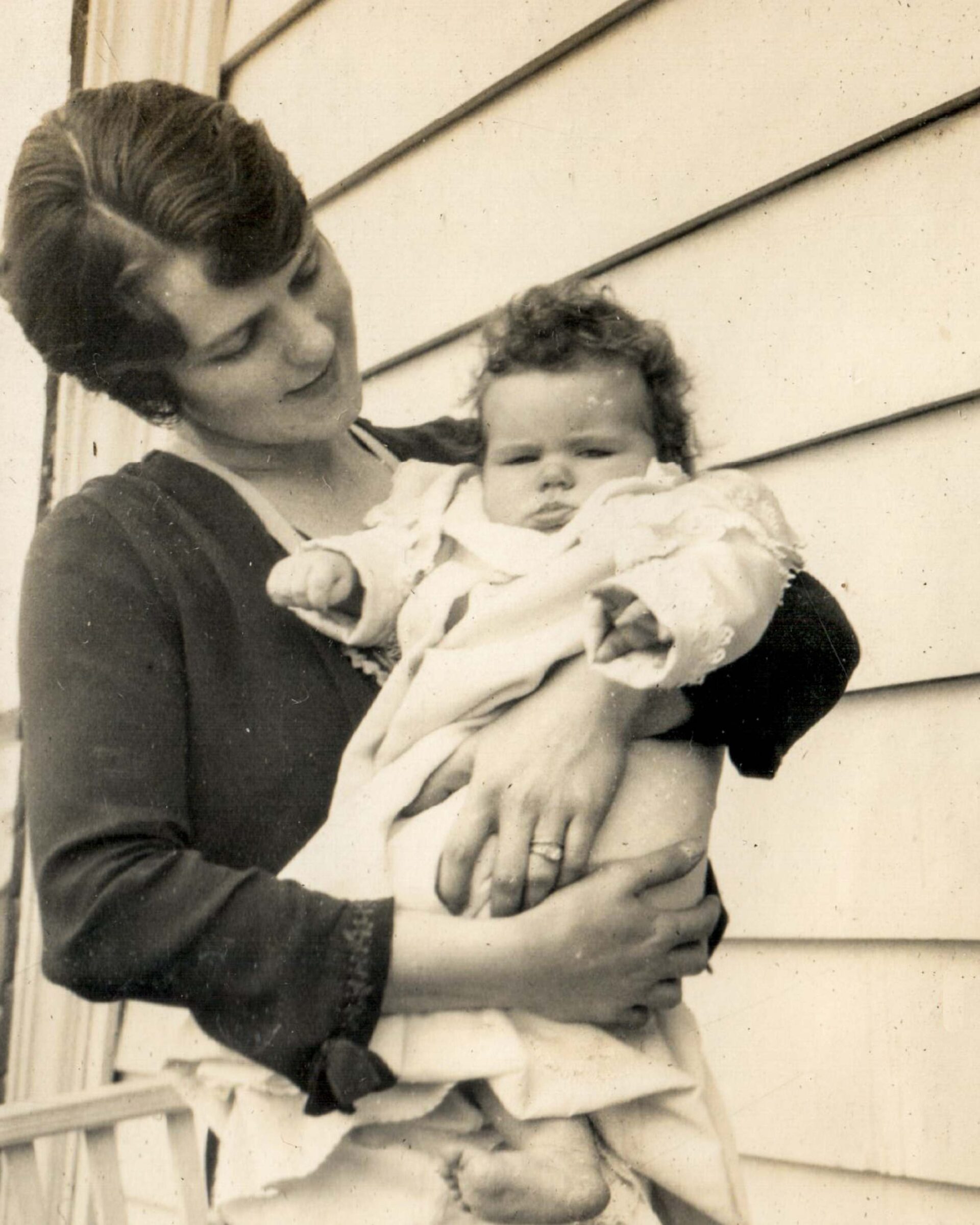 1920s-outdoor-portrait-of-smiling-mother-holding-baby-vintage-photography