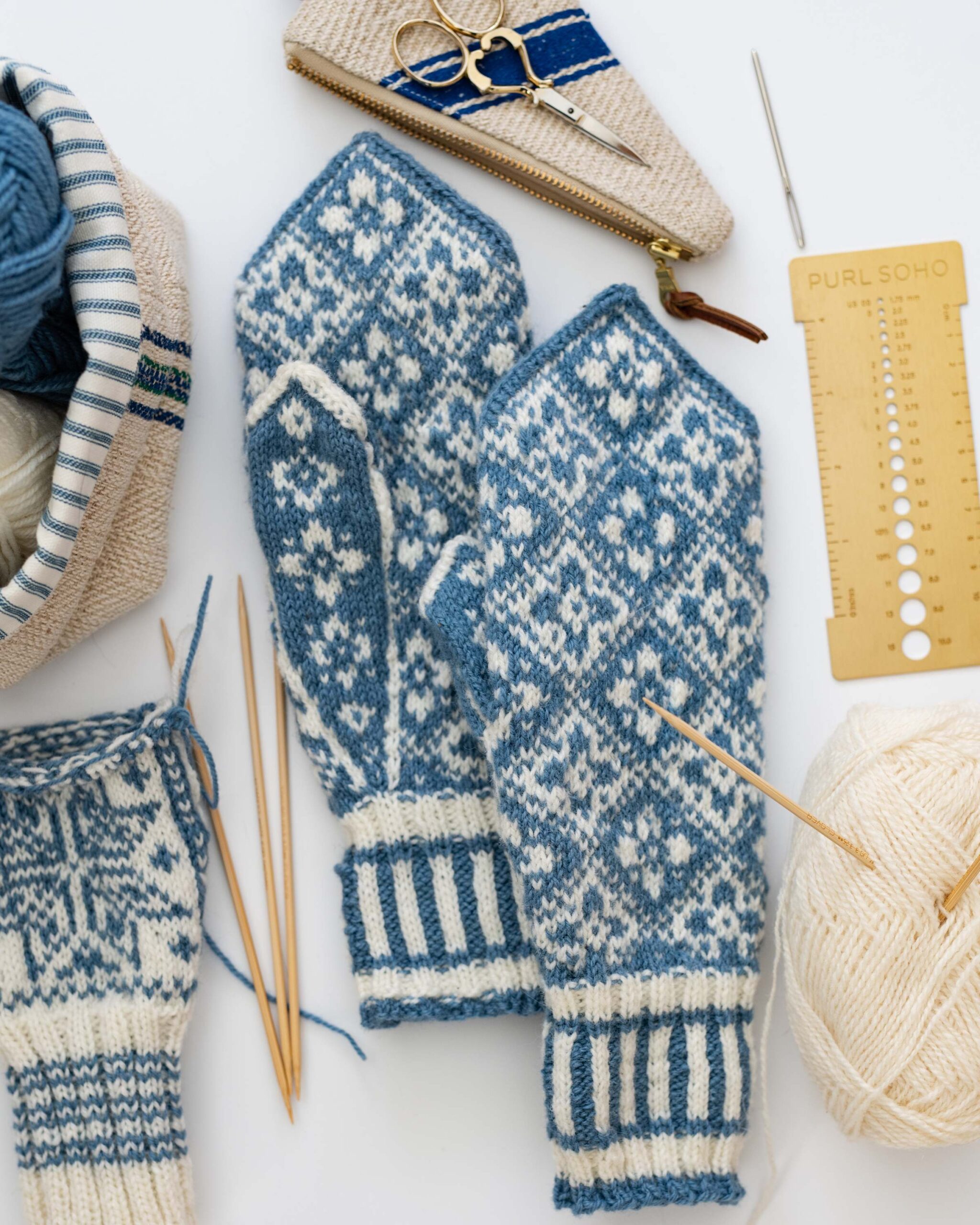 Blue and White Hand-Knitted Nordic Mittens with Knitting Tools Flat Lay Crafting Setup artist reference photo