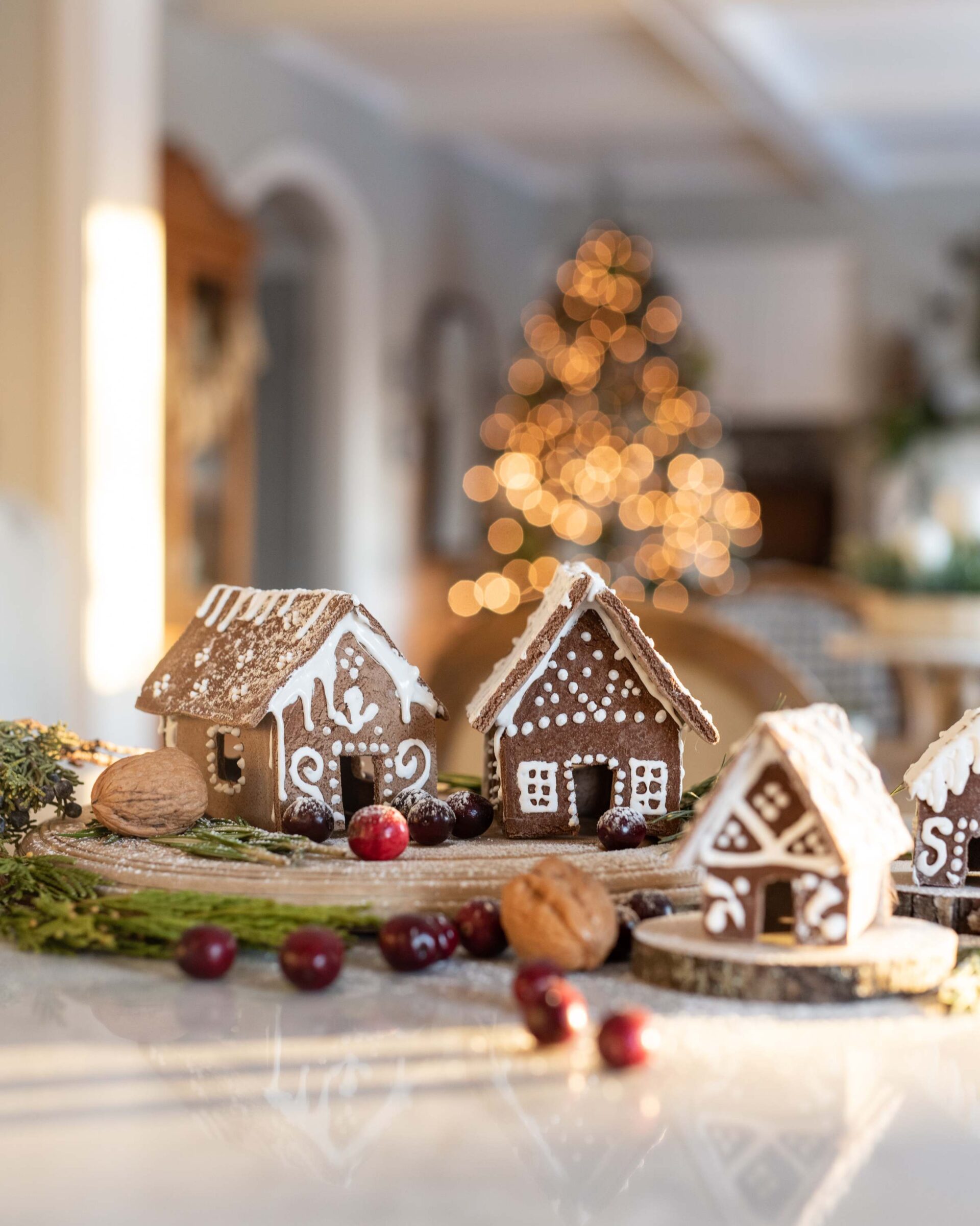 charming-christmas-gingerbread-village-display-featuring-intricately-decorated-cookie-houses-with-white-icing-sprinkles-and-walnut-accents