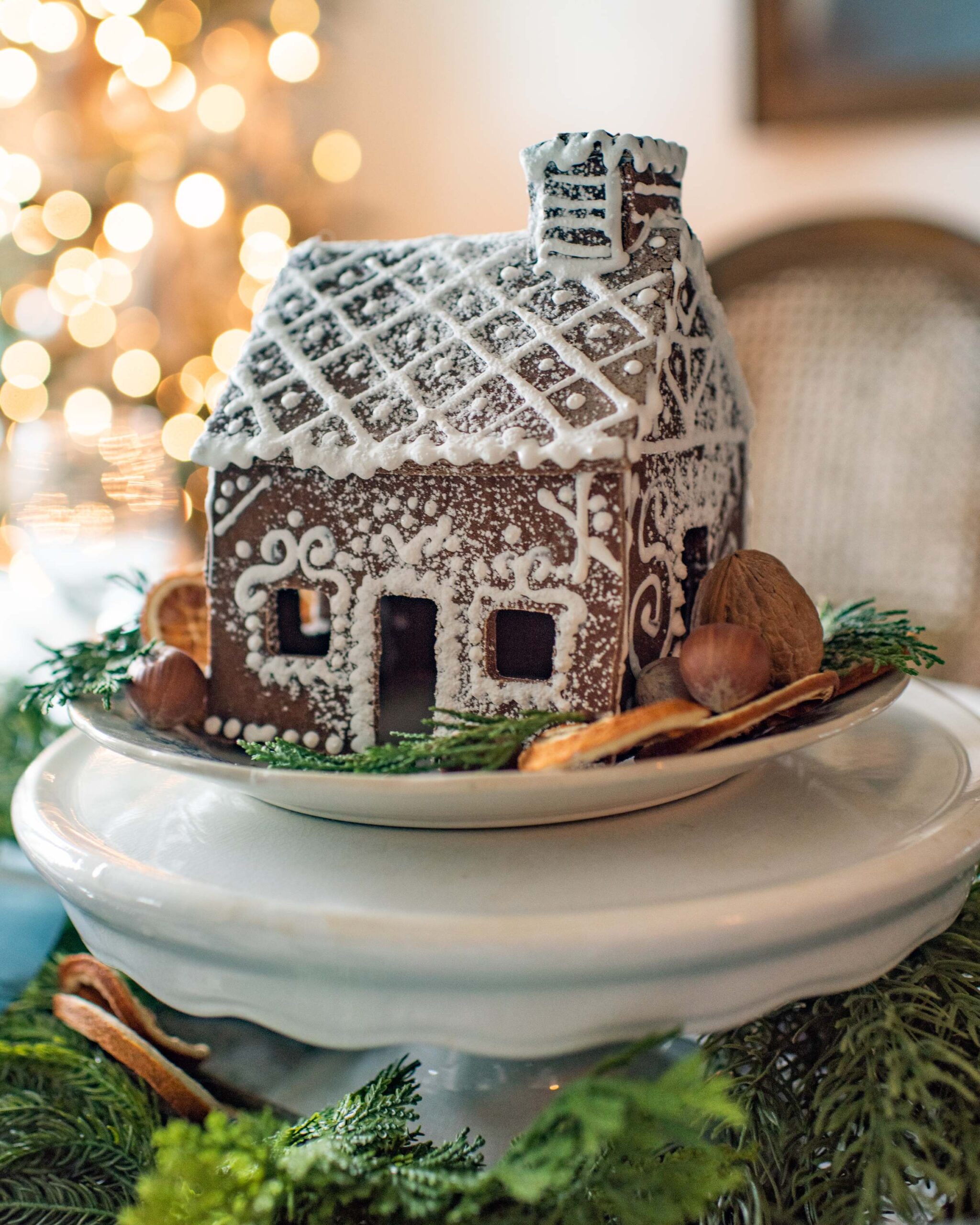 Charming gingerbread house with intricate white icing designs on a festive holiday table setting artist reference photo