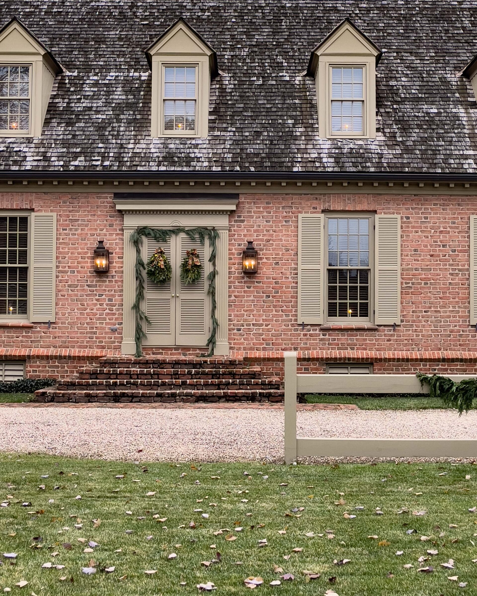 classic-colonial-brick-house-with-symmetrical-windows-and-greenery-decor