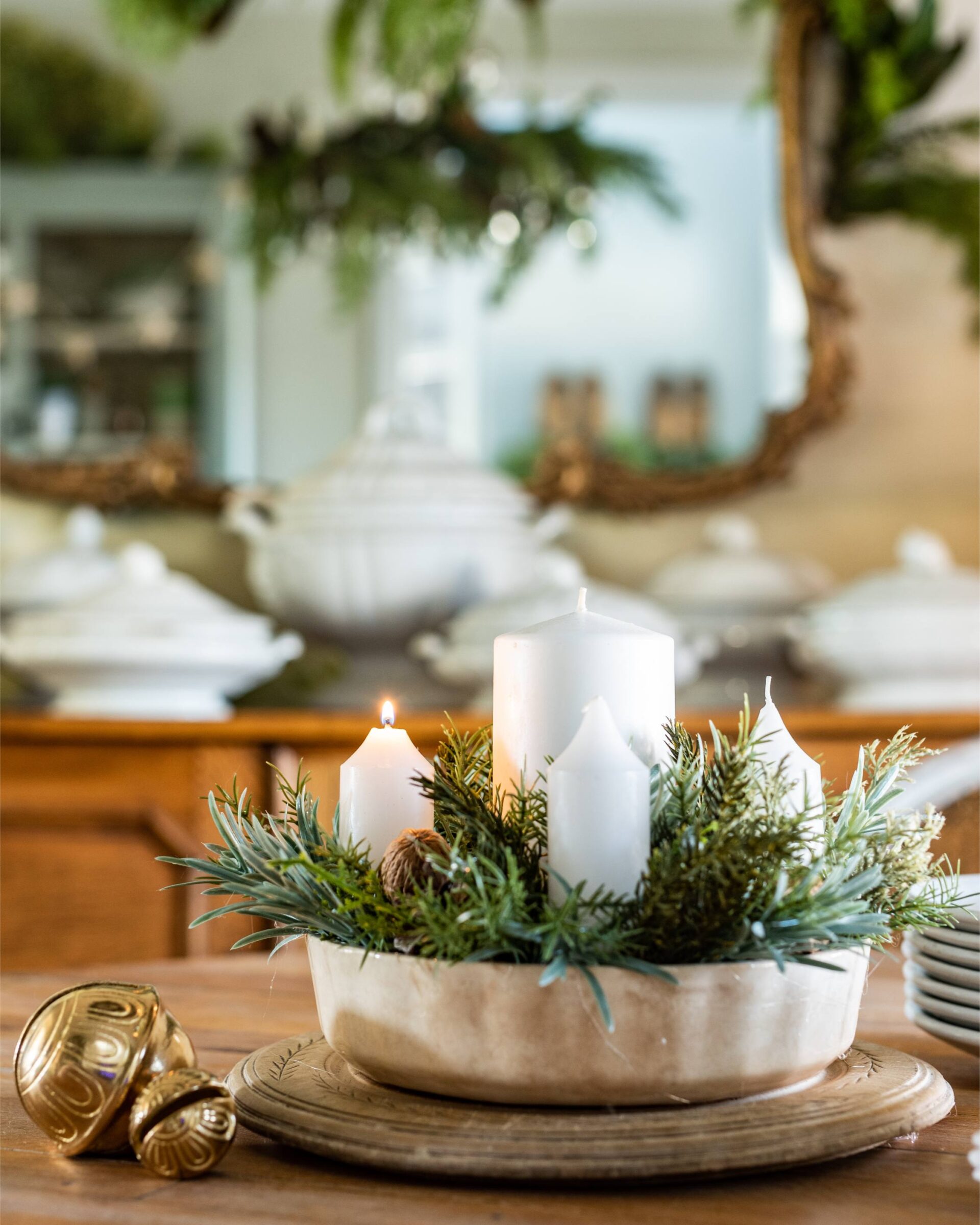 elegant-christmas-centerpiece-with-white-candles-evergreen-sprigs-and-gold-accents-in-a-rustic-bowl