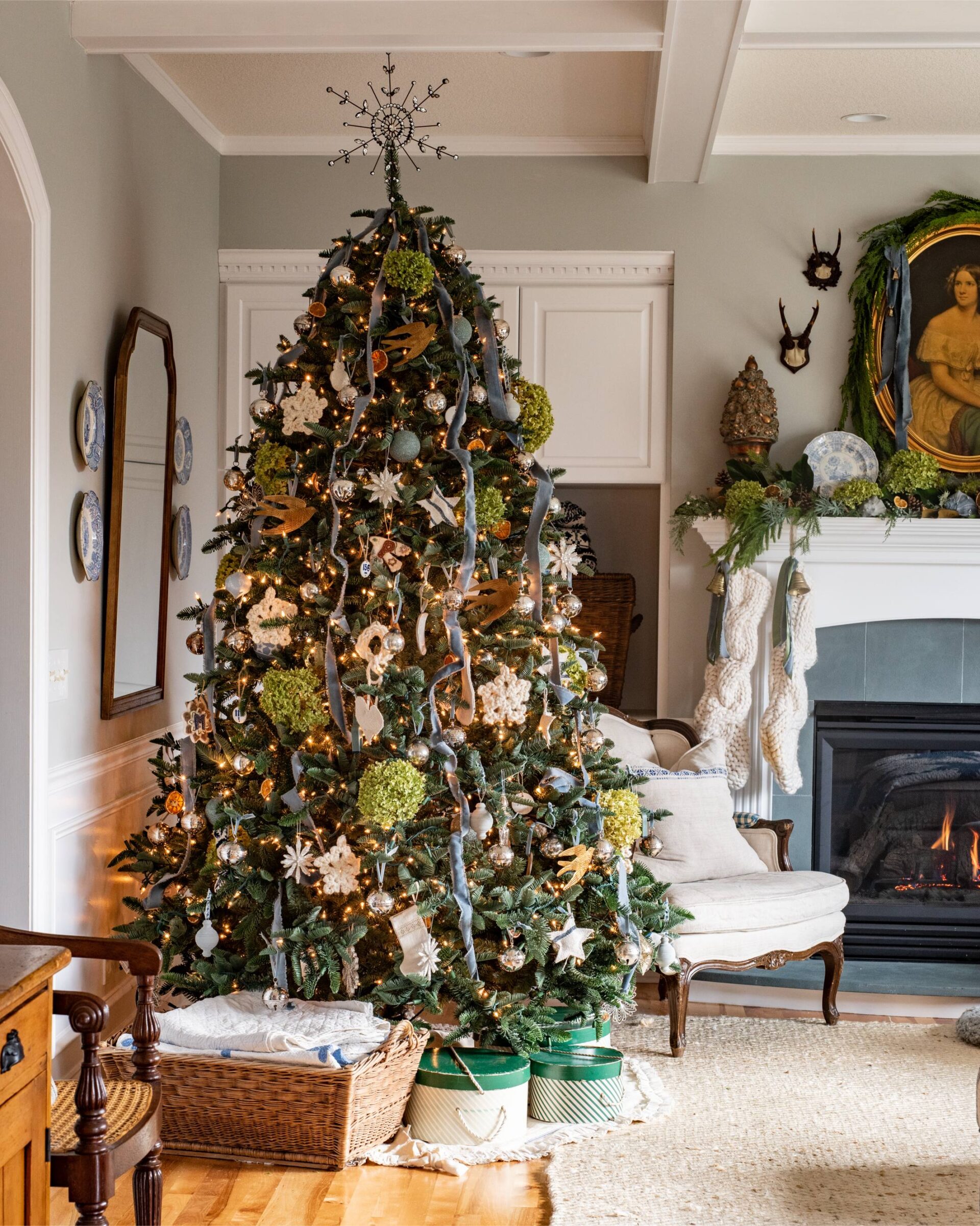 elegant-christmas-tree-decorated-with-natural-green-and-gold-accents-handmade-ornaments-and-ribbon-set-beside-a-cozy-fireplace-and-traditional-holiday-decor-in-a-classic-living-room