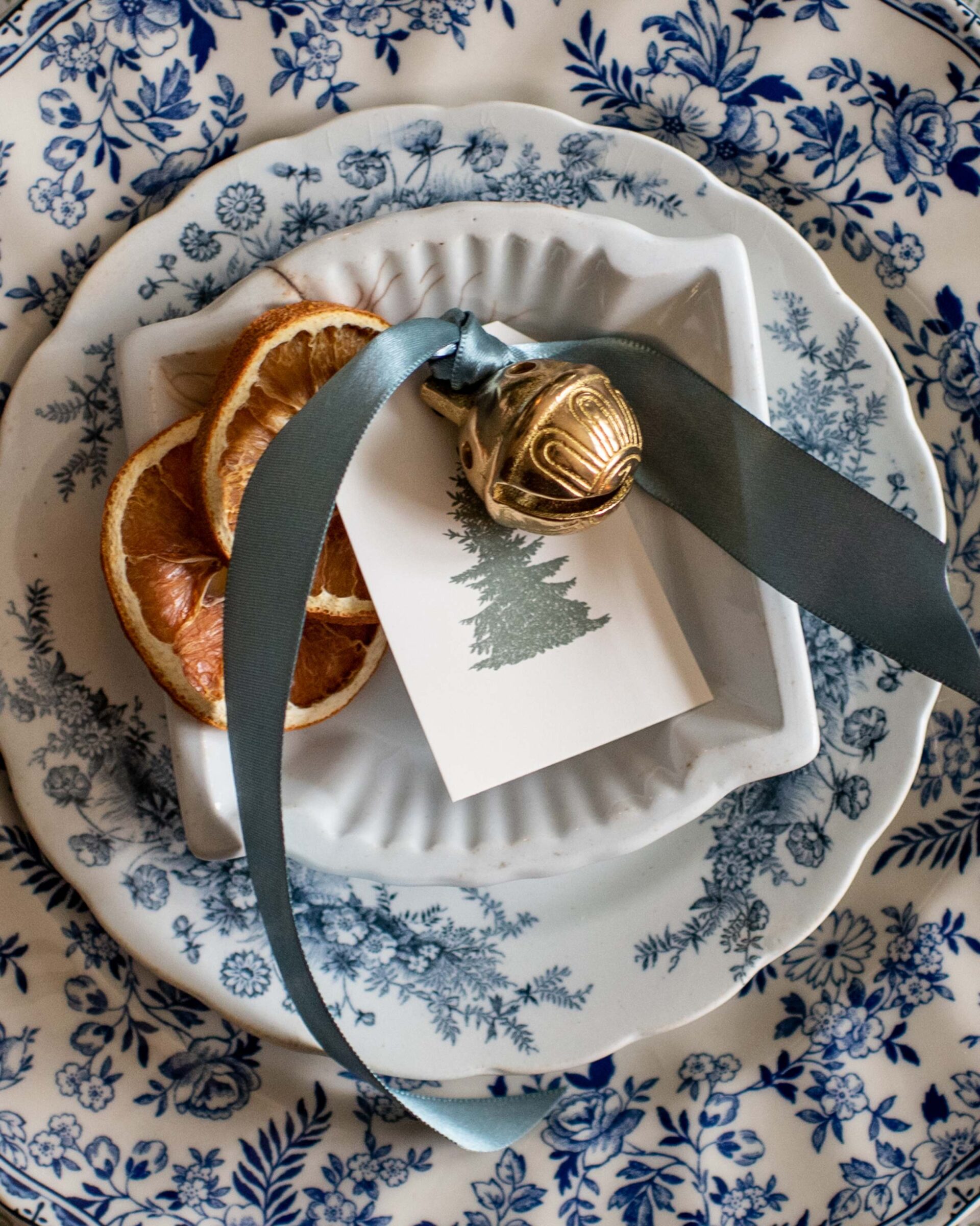 festive-holiday-place-setting-with-dried-orange-slices-and-ornament-on-blue-floral-plate