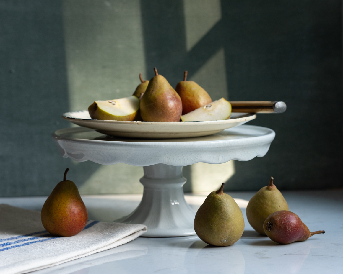 fresh-pears-on-cake-stand-with-rustic-linen-and-natural-light-still-life