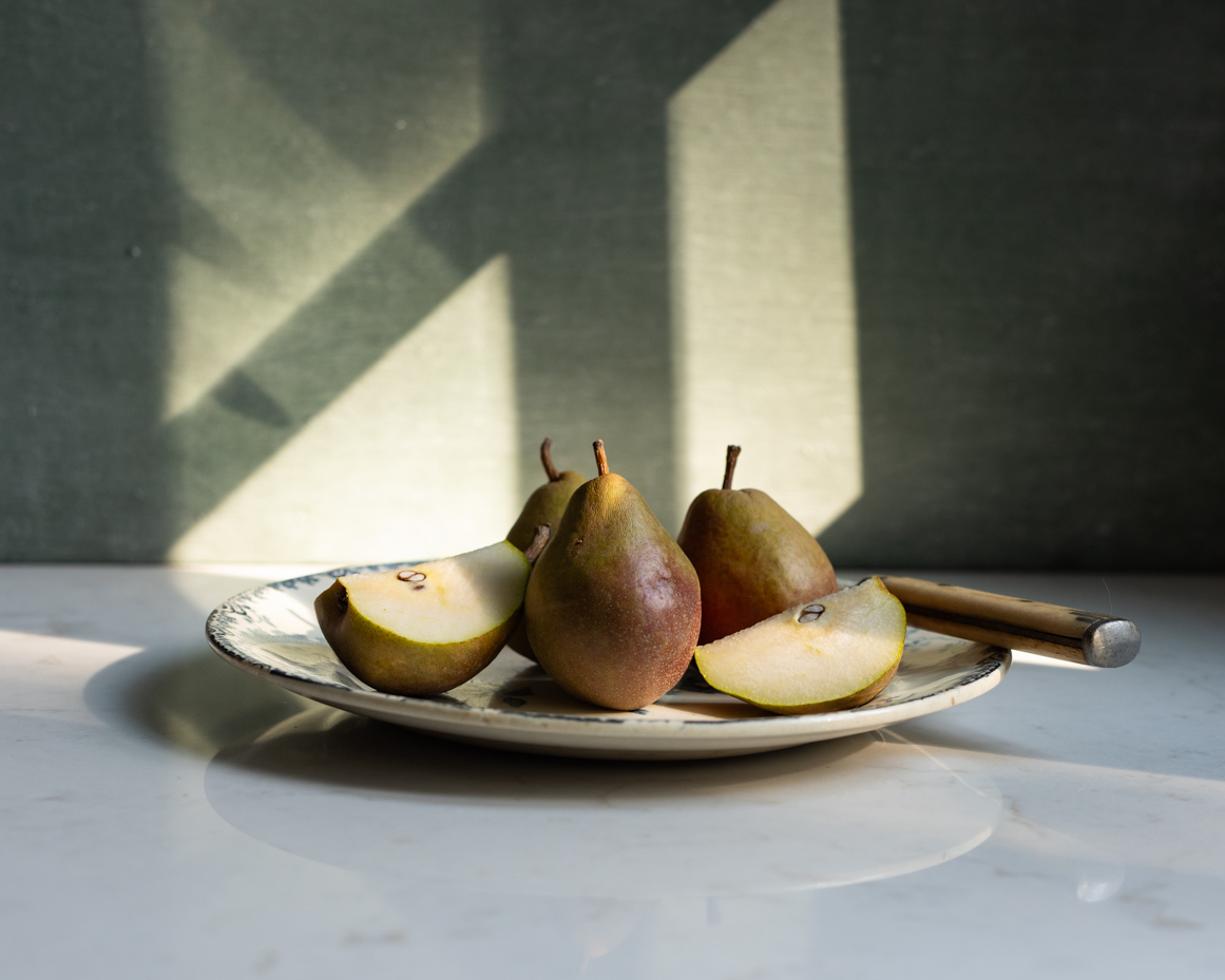 fresh-pears-on-plate-with-natural-light-and-shadows-rustic-still-life