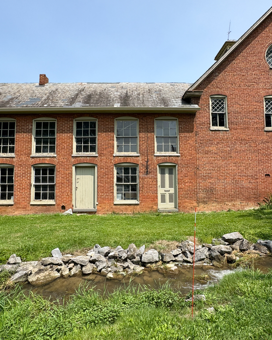 historic-brick-farmhouse-stream-stone-wall-rural-architecture