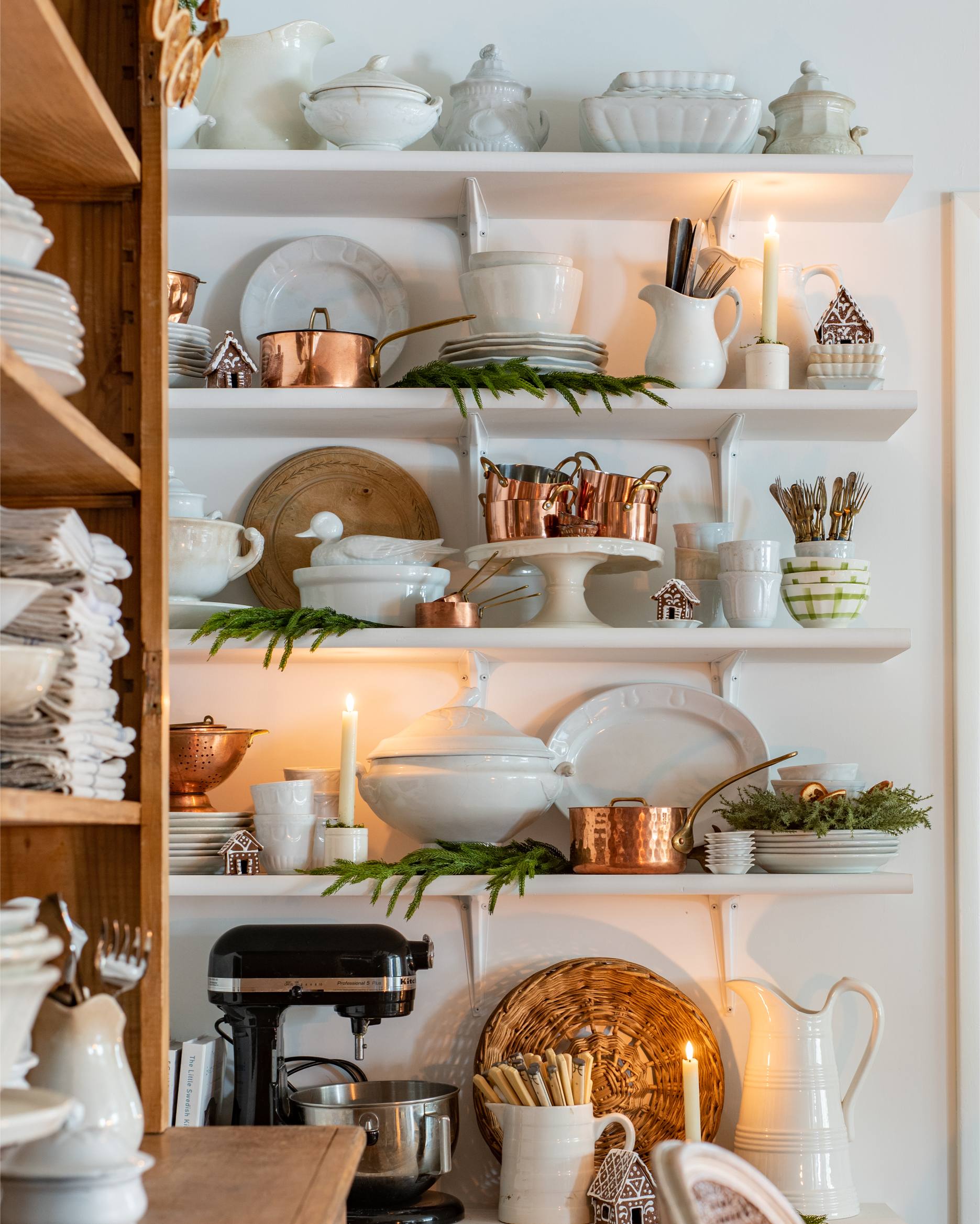 holiday-kitchen-shelf-styling-with-white-ceramics-copper-pots-greenery-candlelight-and-mini-gingerbread-houses