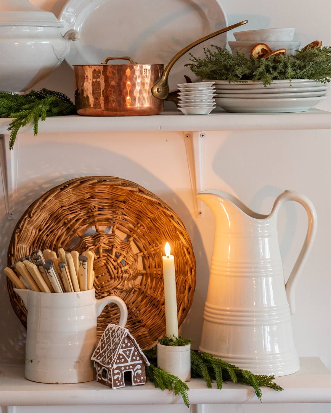 holiday-shelf-decor-with-copper-pot-wicker-tray-white-pitcher-candles-and-miniature-gingerbread-house