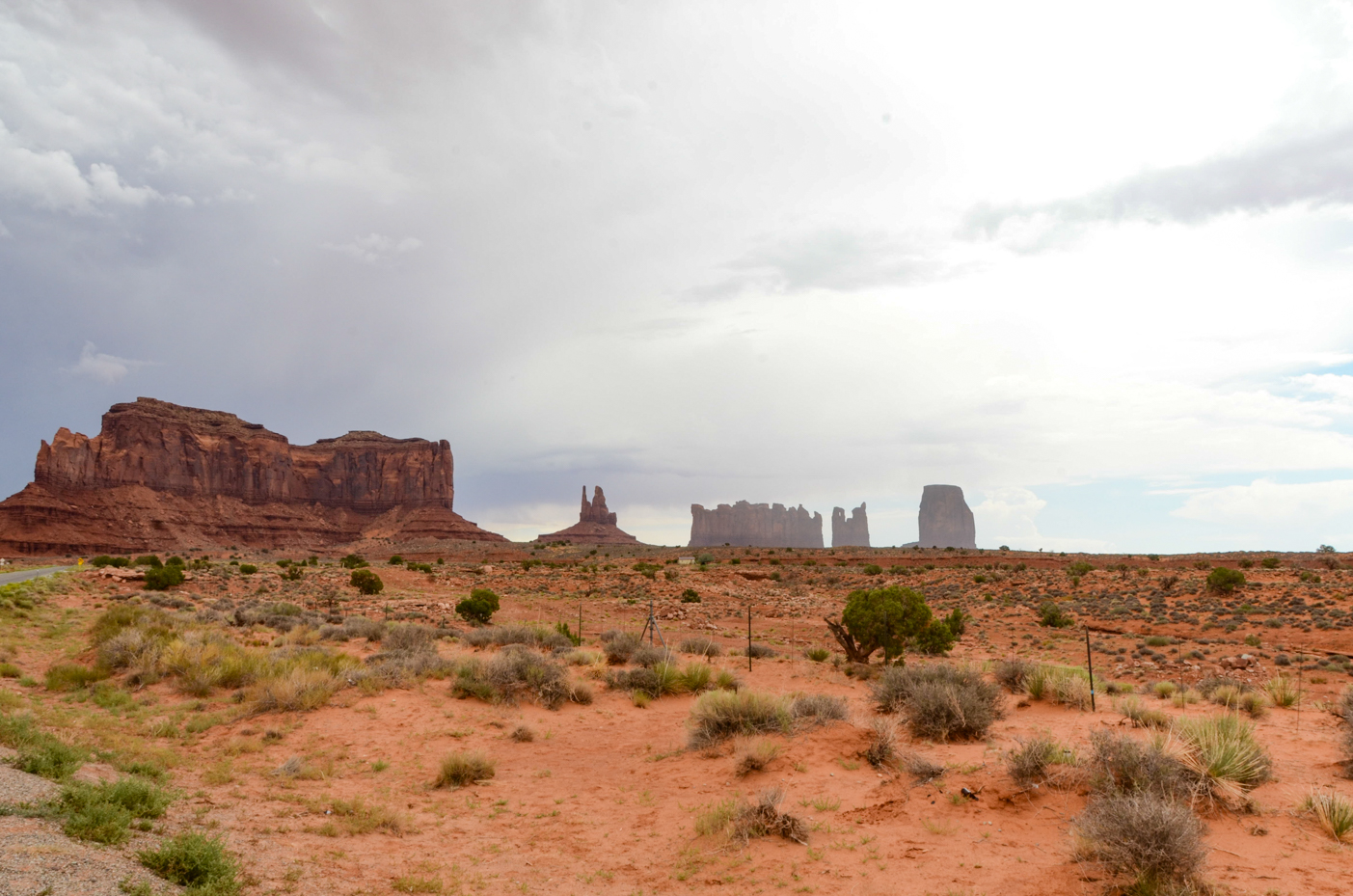 iconic-monument-valley-mesas-across-red-desert-plain-under-gathering-storm-clouds