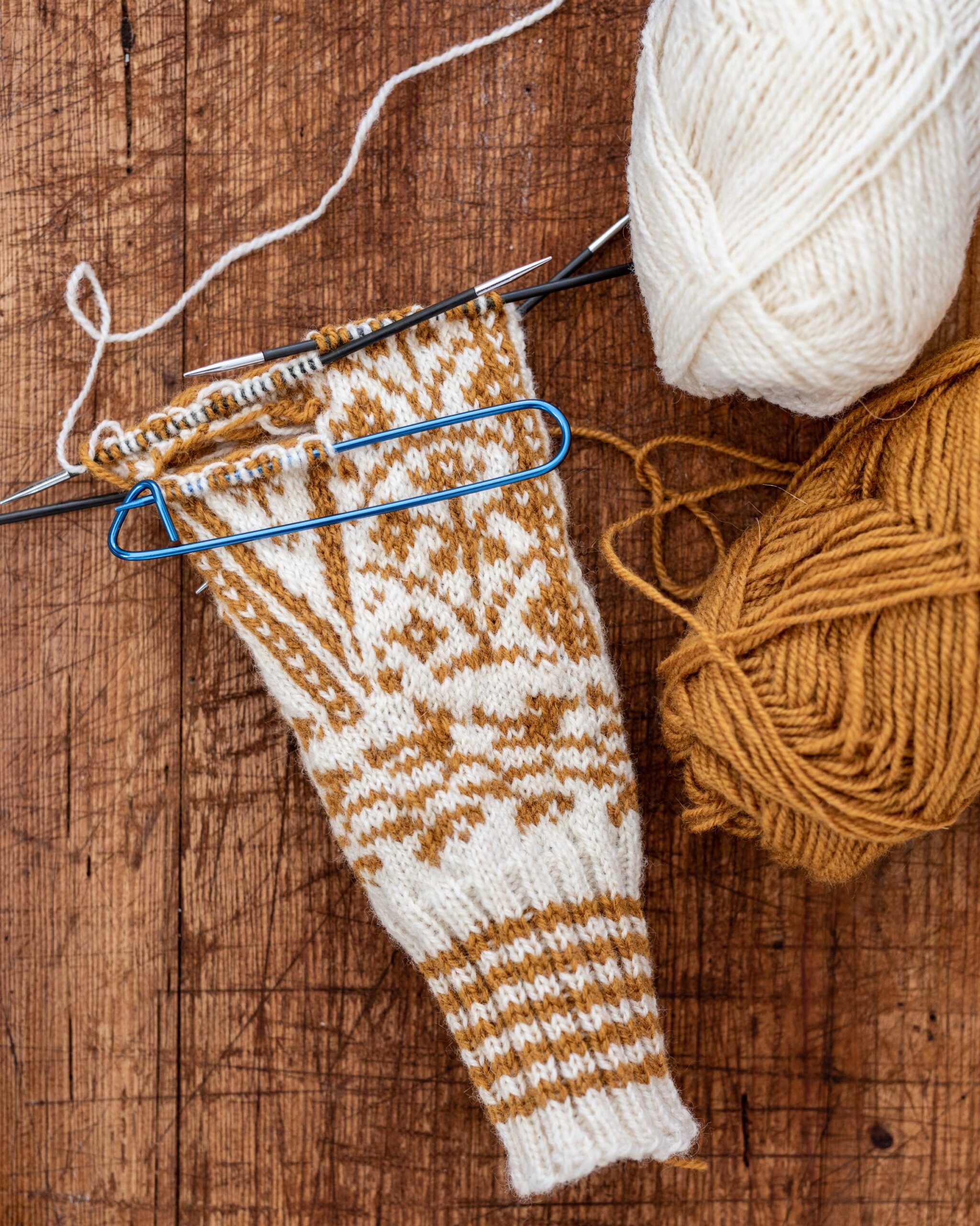 Nordic Pattern Knitting in Progress with Mustard and White Yarn on Wooden Background artist reference photo
