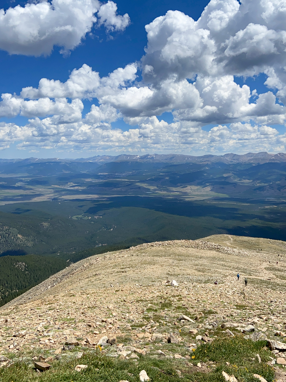 aerial-view-of-rocky-alpine-ridge-with-distant-lakes-and-forests-under-dramatic-cloudy-sky-royalty-free-photo