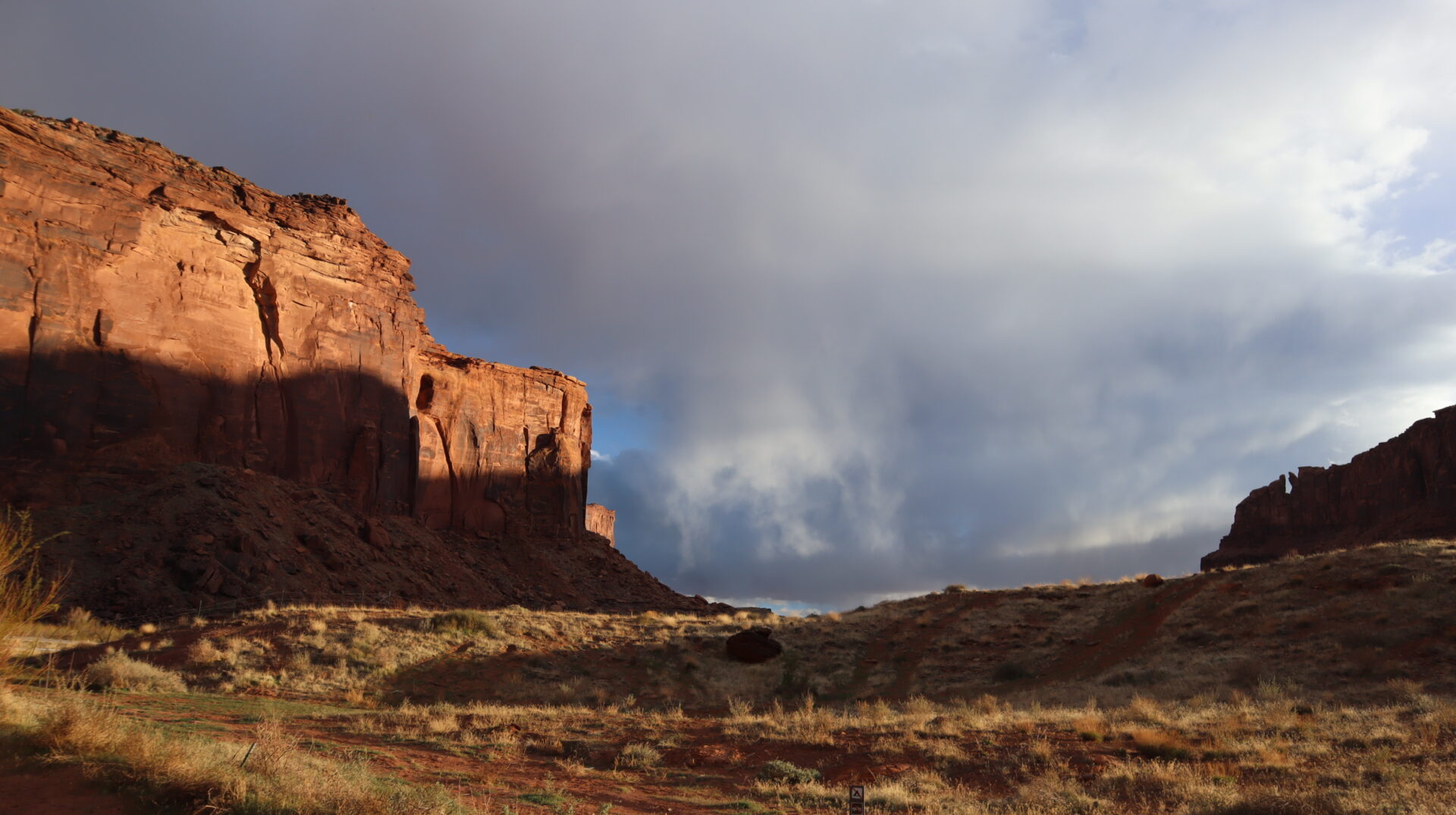 dramatic-red-rock-cliffs-under-stormy-sky-in-desert-landscape