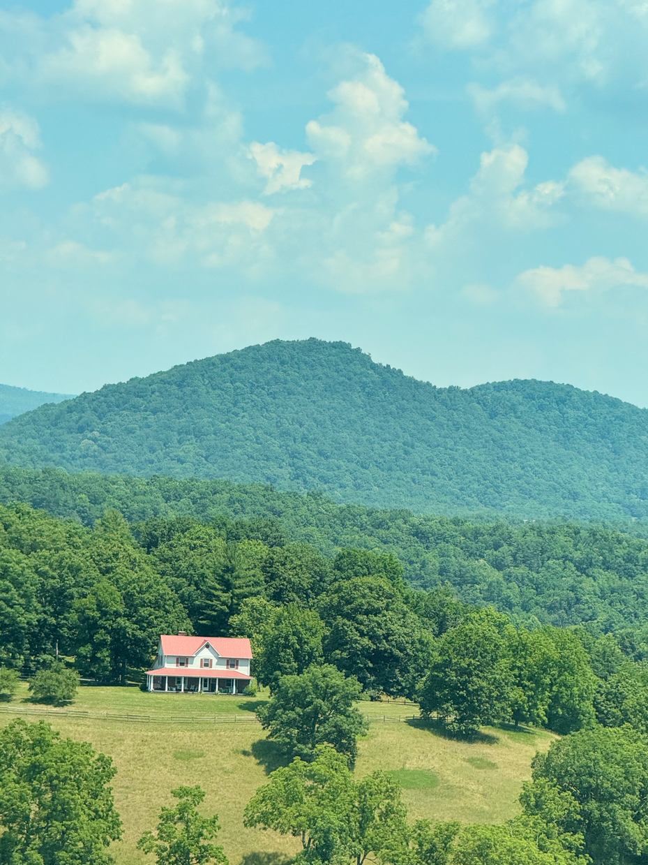 green-forested-mountains-with-snowy-peaks-under-blue-cloudy-sky-scenic-mountain-vista-overlook-royalty-free-photo