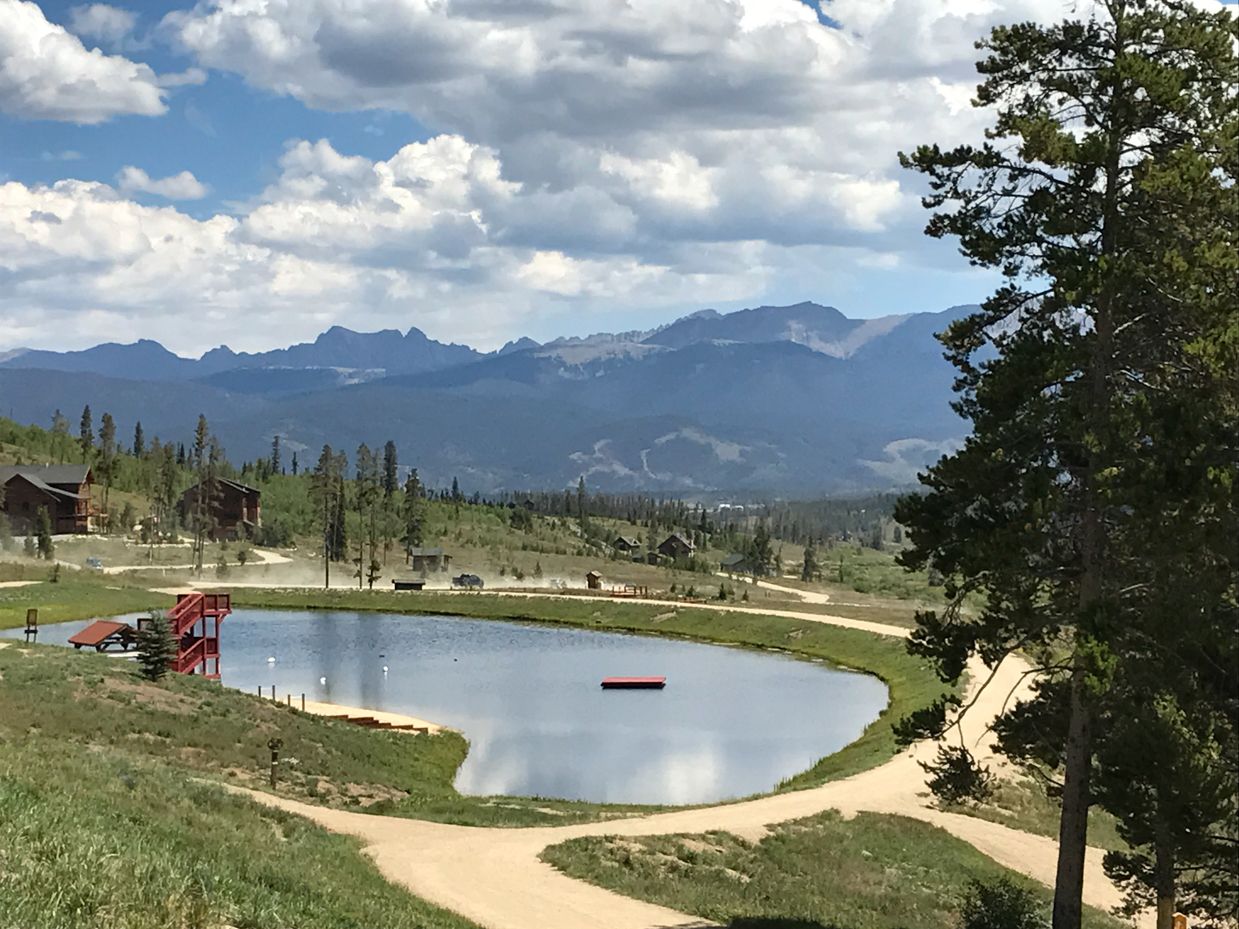 mountain-village-with-pond-cabins-and-dramatic-cloudy-sky-scenic-overlook-royalty-free-photo